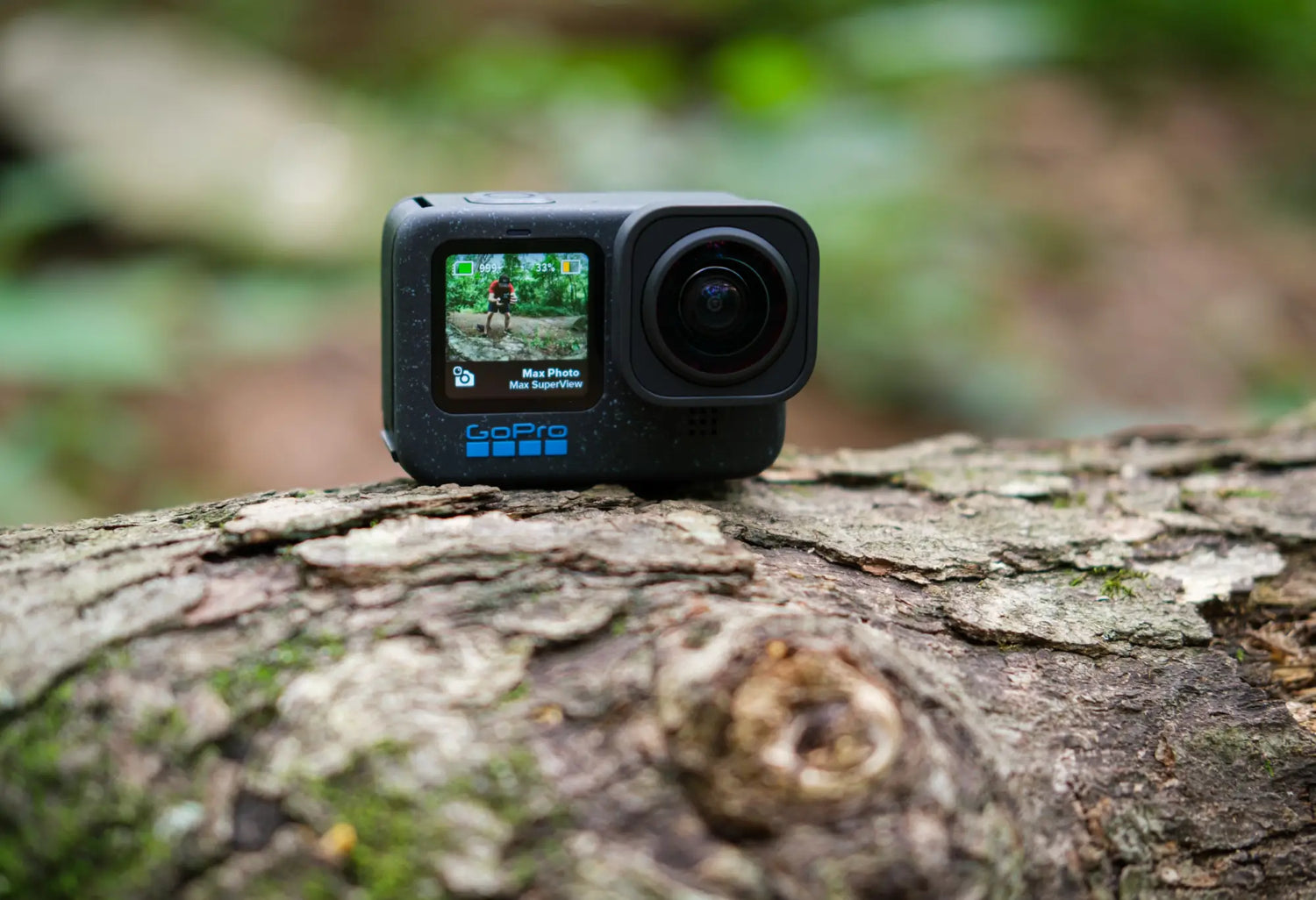 Black action camera with a front-facing screen and a prominent lens.